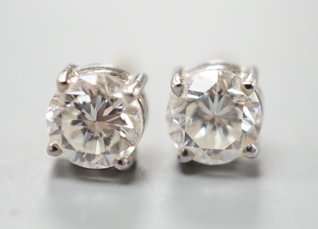 A pair of 18ct gold and solitaire diamond set ear studs, stone diameter approx. 4.8mm, gross weight 1.2 grams.